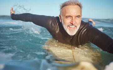 Älterer Schwimmer im Meer als Symbol für Vitalitätsversprechen
