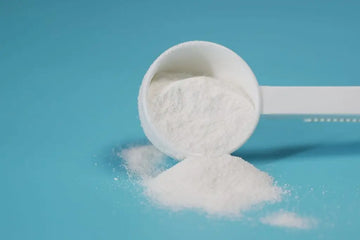 Milchpulver mit Dosierlöffel auf einer Küchenoberfläche