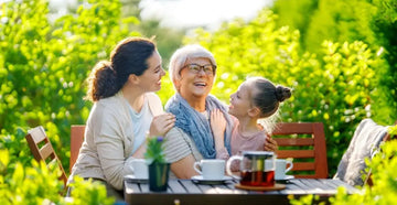 Familie trinkt Tee gemeinsam im Garten