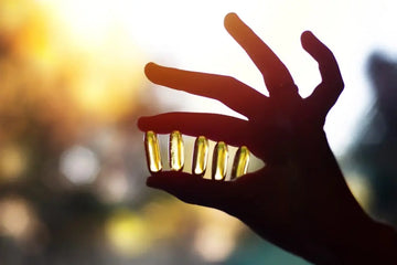 Hand hält Omega-3-Kapseln als Beispiel für Fischölpräparate