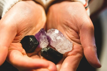 Hände halten verschiedene Edelsteine und Kristalle