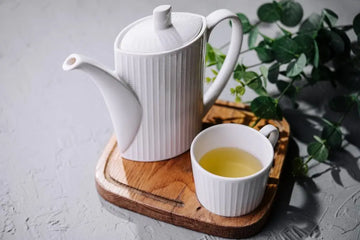 Japanischer grüner Tee in weißer Tasse und Teekanne