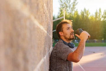 Sportler trinkt nach dem Training aus einem Shaker