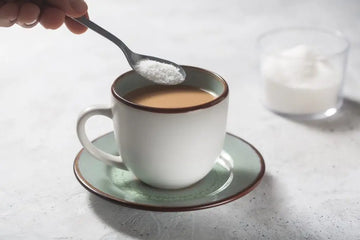 Kaffee wird mit Milch und Süßstoff zubereitet