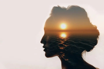 Ruhige Frau am Meer als Symbol für psychisches Wohlbefinden