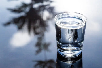 Klares Wasser in einem Glas mit Lichtreflexen