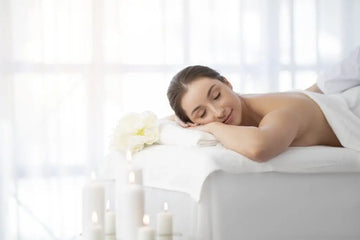 Frau liegt entspannt auf einer Massageliege im Wellnessbereich