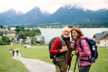 Älteres Paar geht mit Nordic-Walking-Stöcken durch die Natur