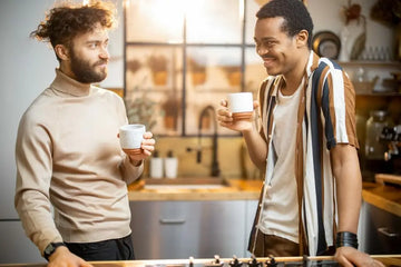 Zwei Personen trinken Kaffee und unterhalten sich in der Küche