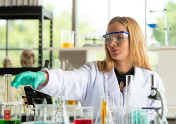 Wissenschaftlerin arbeitet kontrolliert in einem Chemielabor